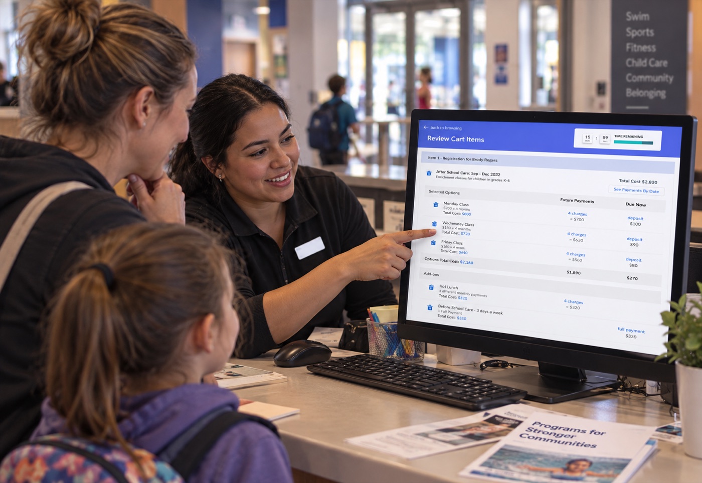 A community center staff member walking a parent and child through the TractionRec review cart screen